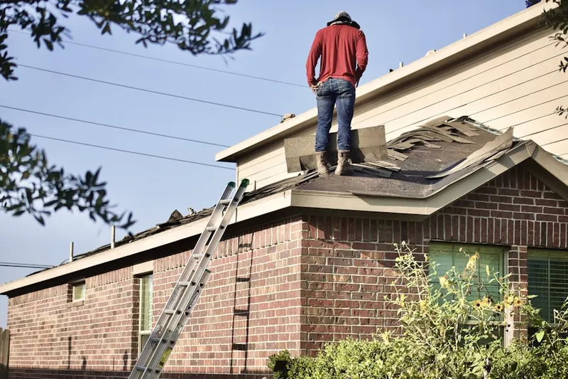 Professional roofer working on a residential roof in Scantic